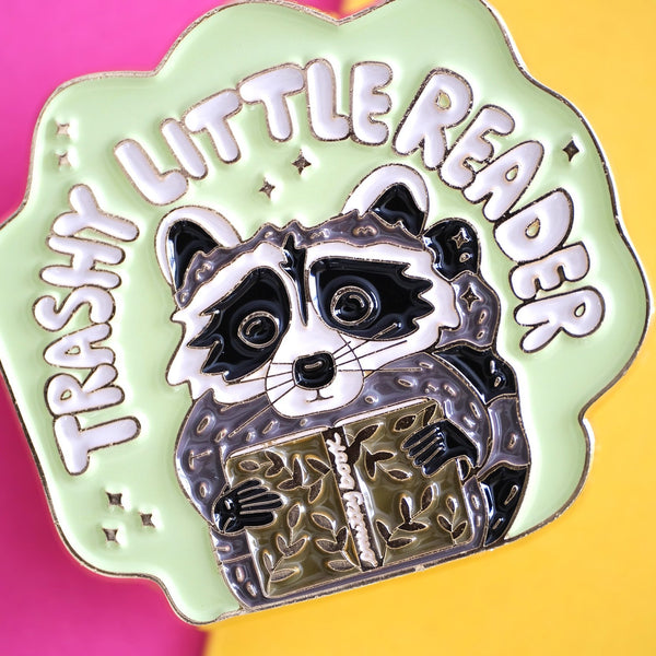 611fc05e3c4ce80992caae23_trashy-little-reader-racoon-pin-4_1790864758937.jpg