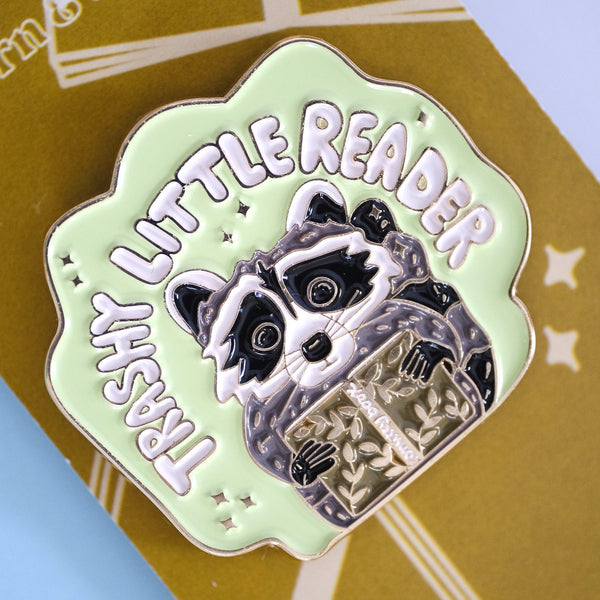 611fc05e3c4ce80992caae23_trashy-little-reader-racoon-pin-5_1790864758937.jpg